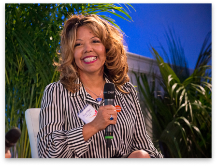 Lucy McBath speaking into a microphone at the 2020 LA Oscar Event.
