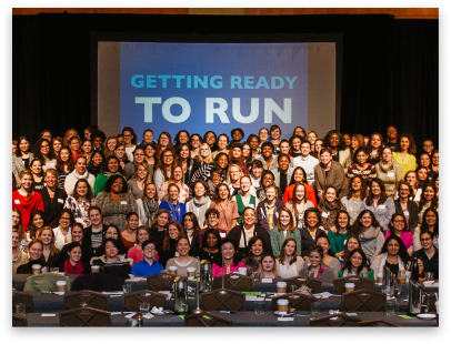 A group picture featuring several Emily's List candidates, with a banner in the background stating "GETTING READY TO RUN."